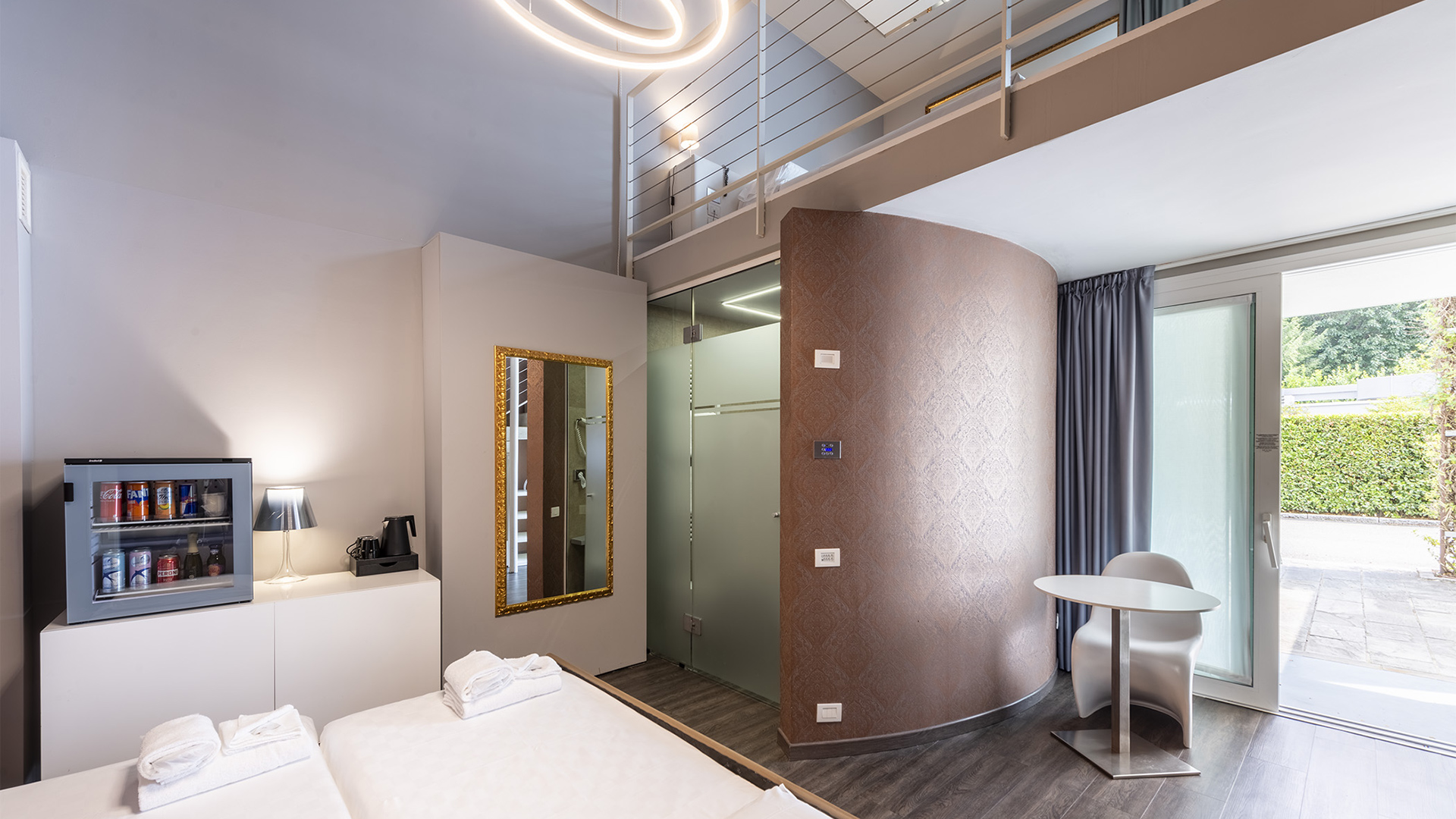 Luxurious two-story family room with three beds, a large window overlooking greenery, a glass ceiling, and mirrors