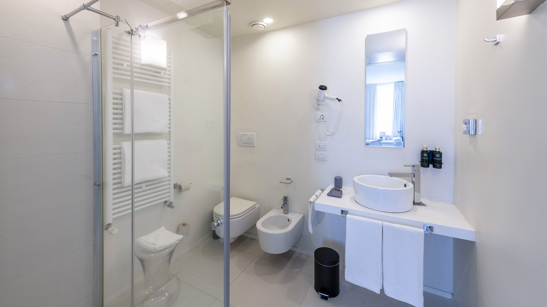 Elegant and serene bathroom of a Superior room, with white walls, light beige tiles, and bright lighting